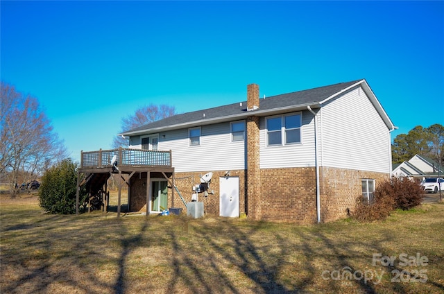 back of house with brick siding, a lawn, a chimney, and a wooden deck