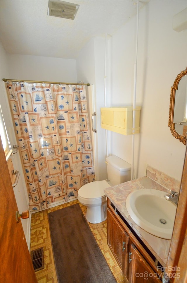 bathroom featuring a shower with curtain, visible vents, vanity, and toilet