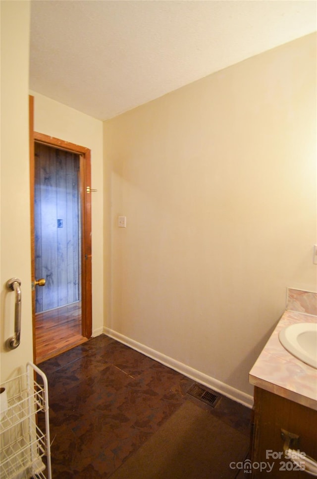 bathroom featuring vanity, visible vents, and baseboards