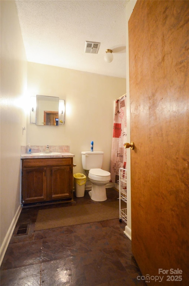 full bath featuring visible vents, vanity, toilet, and a textured ceiling