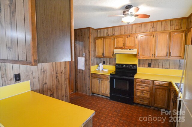 kitchen with wooden walls, a ceiling fan, extractor fan, light countertops, and black electric range