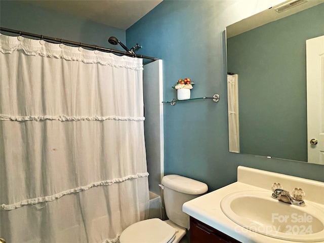 full bath featuring vanity, a shower with shower curtain, toilet, and visible vents