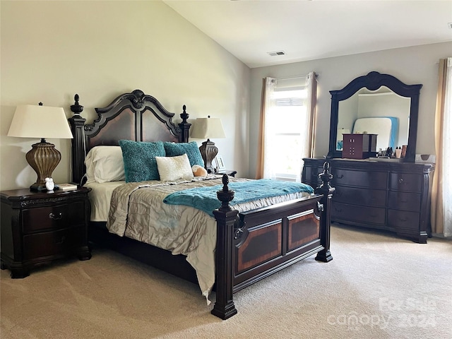 bedroom featuring visible vents, light carpet, and vaulted ceiling