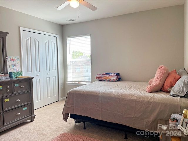 bedroom featuring a closet, visible vents, light colored carpet, and ceiling fan