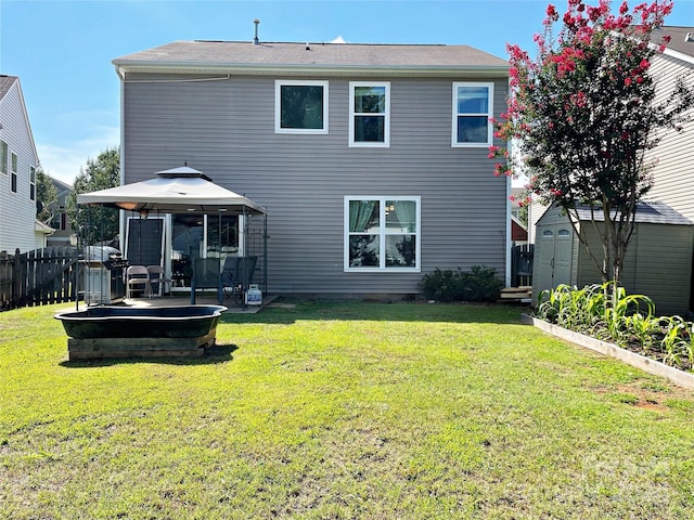 back of property with fence, a gazebo, a shed, an outdoor structure, and a patio area