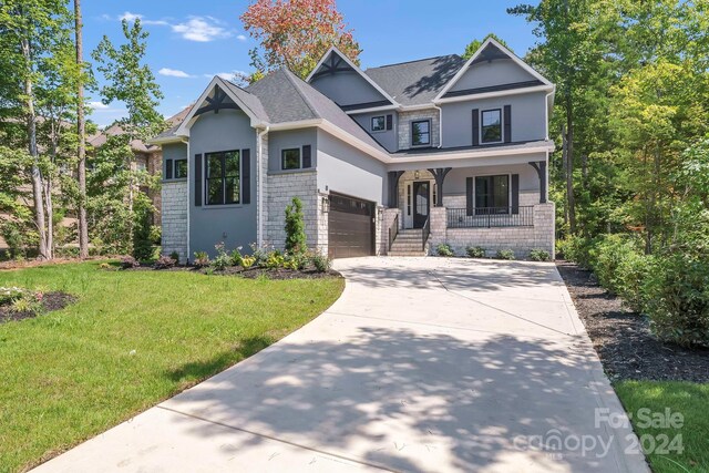 craftsman-style house featuring a porch, a garage, and a front lawn