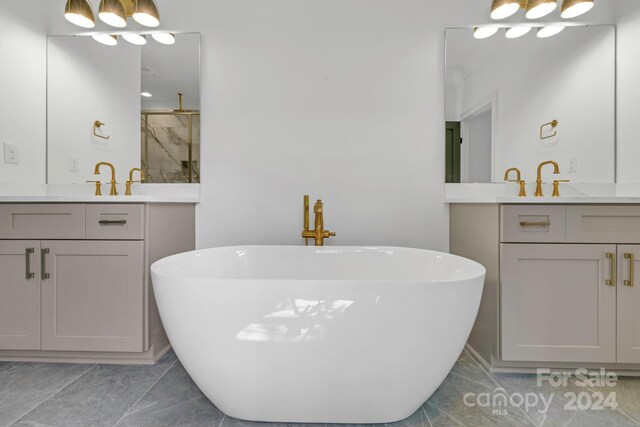 bathroom with double sink vanity, a bathing tub, and tile patterned flooring