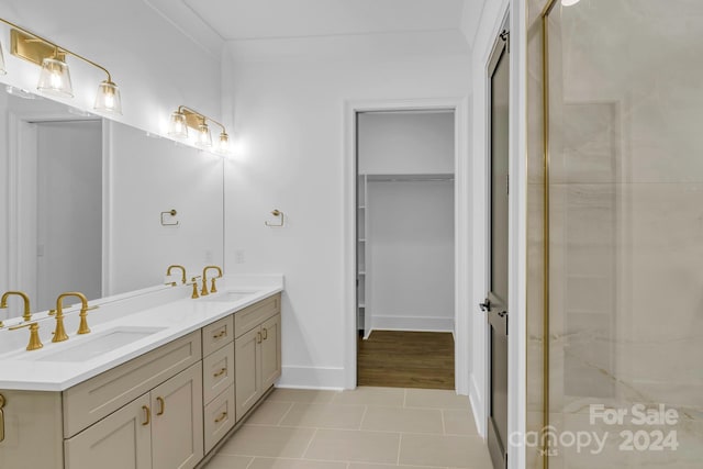 bathroom featuring double sink vanity, an enclosed shower, tile patterned floors, and crown molding