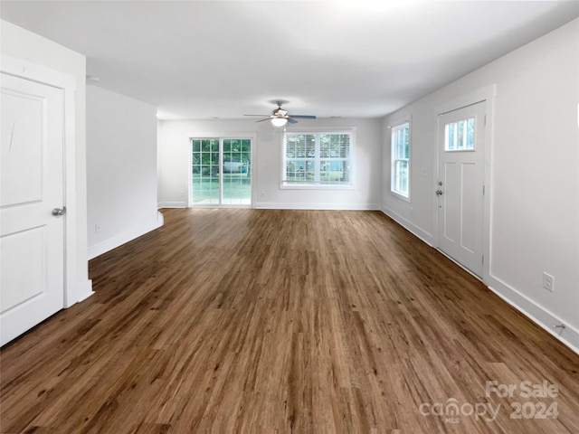 unfurnished living room featuring ceiling fan and dark hardwood / wood-style floors