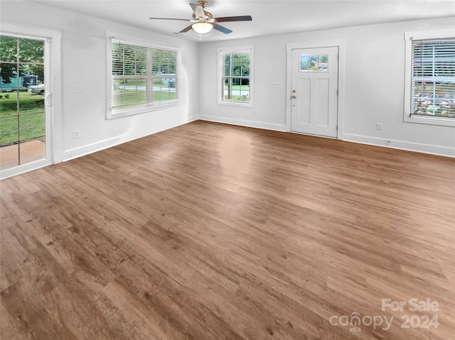 unfurnished living room with ceiling fan and hardwood / wood-style flooring