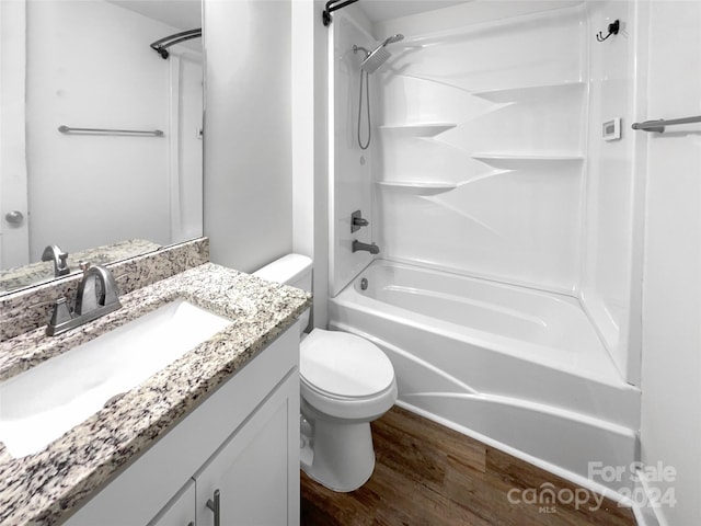 full bathroom with hardwood / wood-style flooring, shower / bathing tub combination, vanity, and toilet