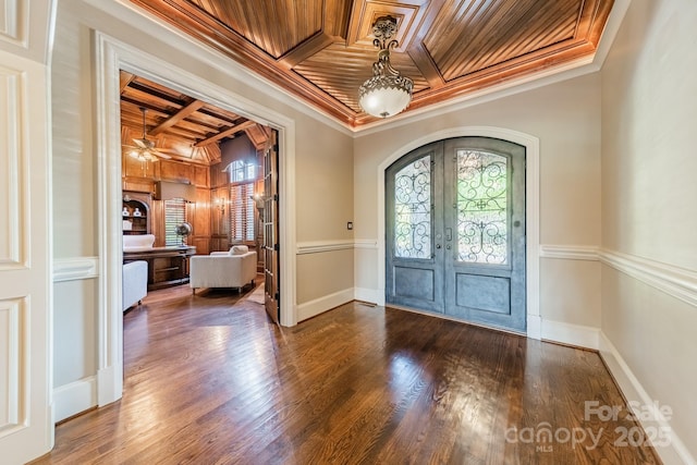 entrance foyer featuring french doors, ornamental molding, ceiling fan, wooden ceiling, and coffered ceiling