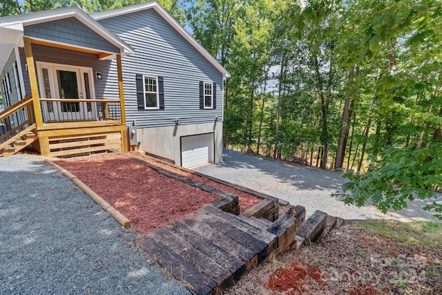 view of front of home featuring covered porch, driveway, and an attached garage