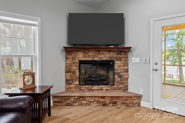 living room with a fireplace and light wood-type flooring