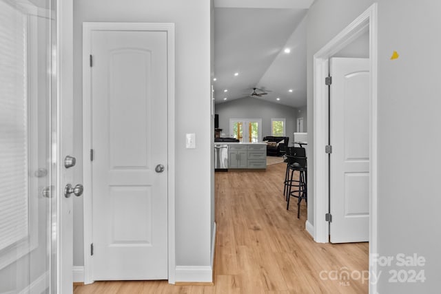 hallway with lofted ceiling and light hardwood / wood-style flooring