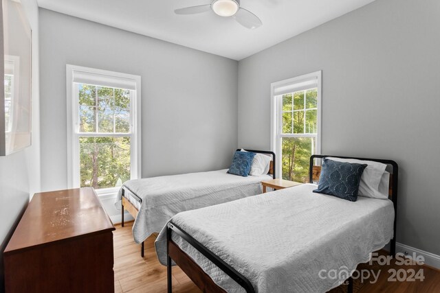 bedroom with multiple windows, ceiling fan, and light hardwood / wood-style floors