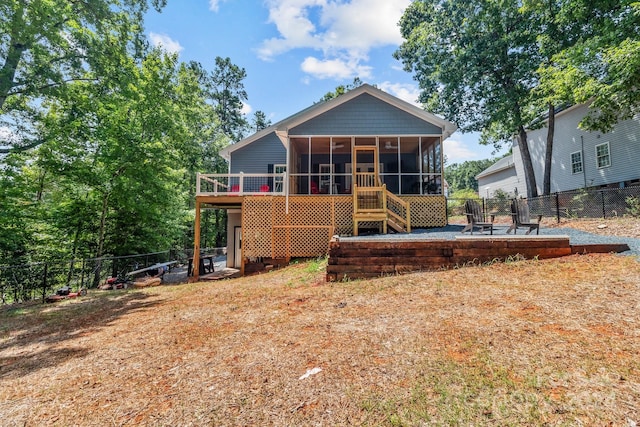 back of property featuring a sunroom and a wooden deck