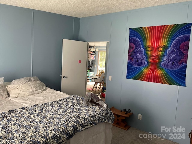 bedroom featuring carpet and a textured ceiling