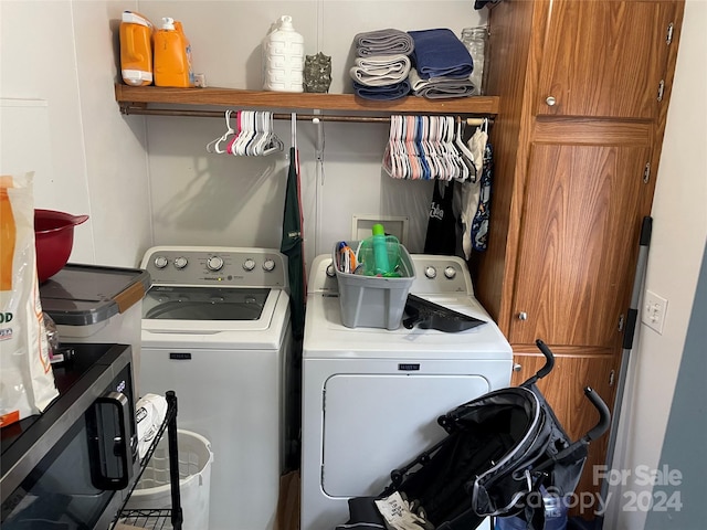 washroom with cabinets and washing machine and clothes dryer