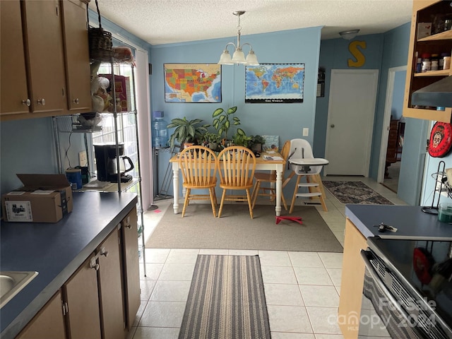 kitchen featuring sink, hanging light fixtures, light tile patterned floors, a textured ceiling, and a notable chandelier