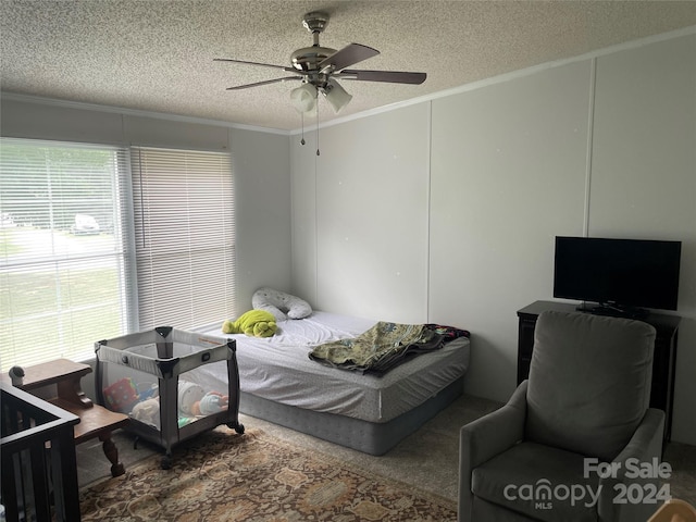 carpeted bedroom featuring crown molding, multiple windows, and a textured ceiling