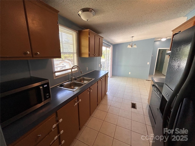 6261 Burnhurst Ln, Denver, NC 28037 - kitchen with a sink, stainless steel microwave, dark countertops, a textured ceiling, and light tile patterned floors