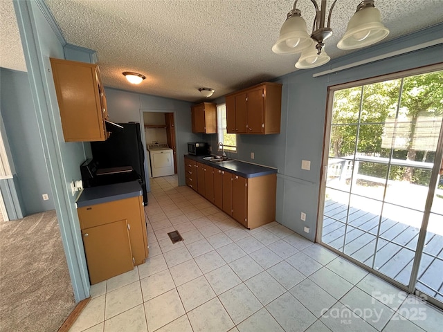 6261 Burnhurst Ln, Denver, NC 28037 - kitchen with washer / clothes dryer, a sink, dark countertops, a textured ceiling, and light tile patterned flooring