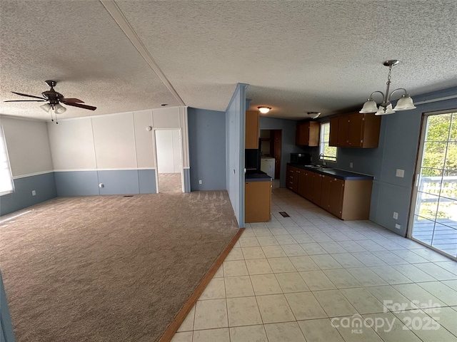 6261 Burnhurst Ln, Denver, NC 28037 - kitchen with open floor plan, a chandelier, dark countertops, a sink, and a textured ceiling