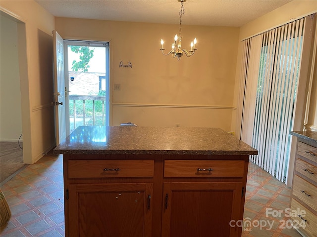 kitchen featuring hanging light fixtures, a textured ceiling, and a chandelier