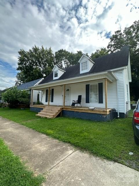 view of front of house featuring covered porch and a front yard