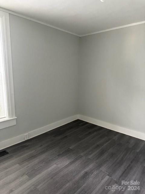 empty room featuring ornamental molding and hardwood / wood-style flooring