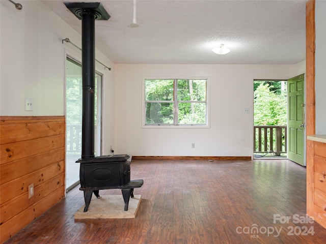 interior space featuring a wood stove, a textured ceiling, and hardwood / wood-style flooring