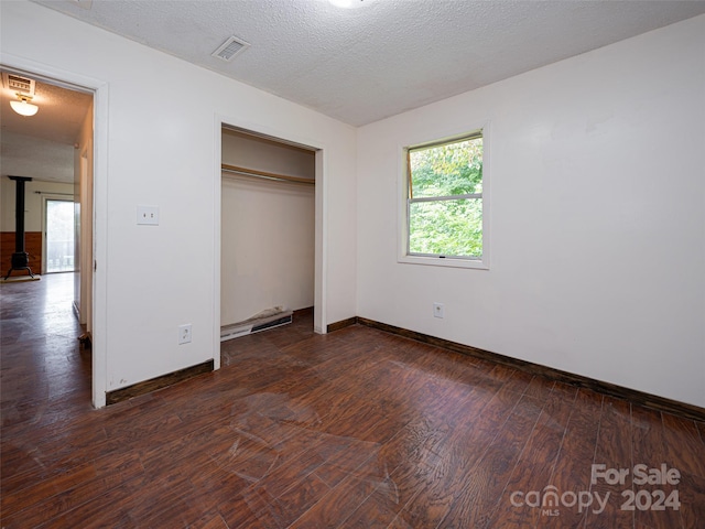 unfurnished bedroom featuring hardwood / wood-style flooring, a closet, and a textured ceiling