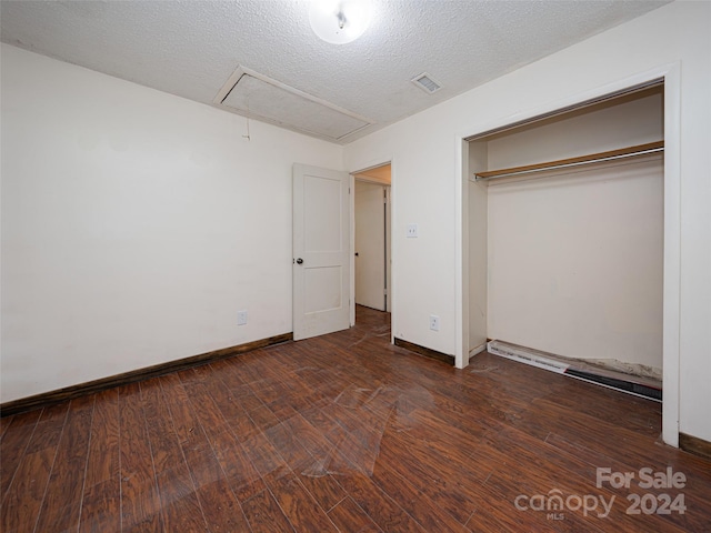 unfurnished bedroom with a textured ceiling, hardwood / wood-style flooring, and a closet