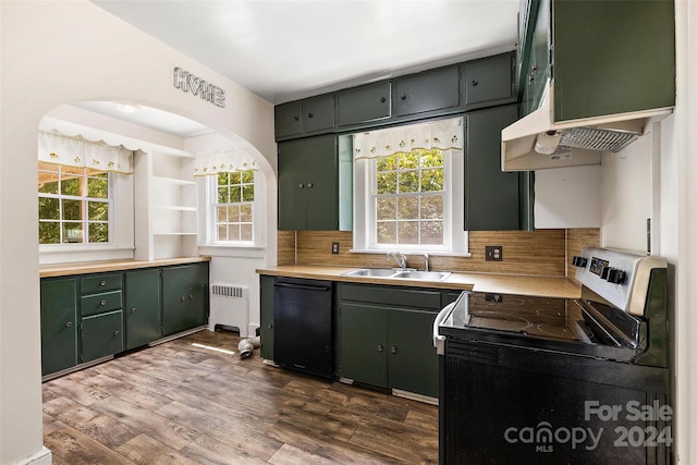 kitchen with radiator heating unit, decorative backsplash, sink, dishwasher, and range with electric cooktop