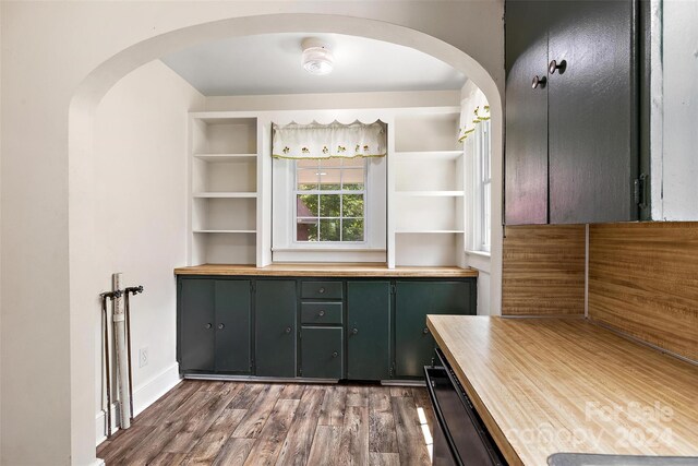 bar featuring dark hardwood / wood-style flooring and green cabinets