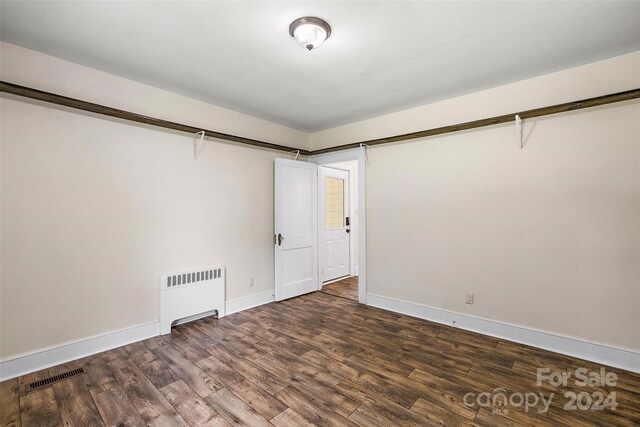 unfurnished room with wood-type flooring and radiator