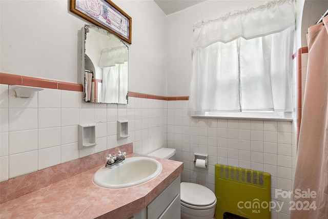 bathroom featuring tile walls, toilet, vanity, and radiator heating unit