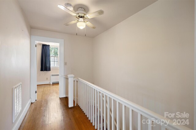 hallway featuring radiator and hardwood / wood-style floors