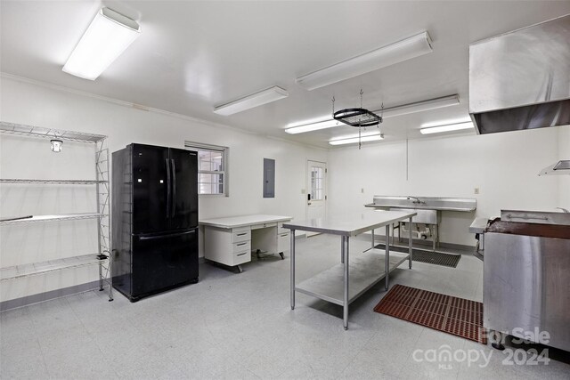 kitchen featuring black fridge, electric panel, light tile patterned floors, and crown molding