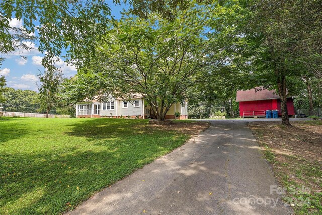 obstructed view of property featuring a front lawn