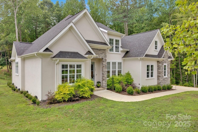 view of front of house with stone siding, a front lawn, a shingled roof, and stucco siding