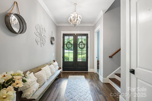 foyer with french doors, dark hardwood / wood-style floors, crown molding, and a notable chandelier