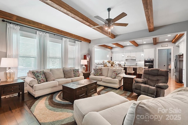 living room featuring beamed ceiling, dark hardwood / wood-style floors, and ceiling fan