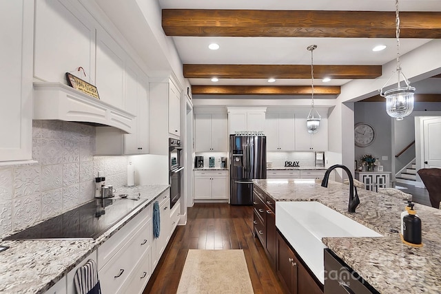 kitchen with beam ceiling, light stone countertops, stainless steel appliances, and white cabinetry