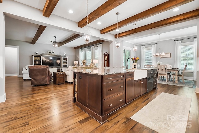 kitchen featuring sink, a center island with sink, hanging light fixtures, and ceiling fan