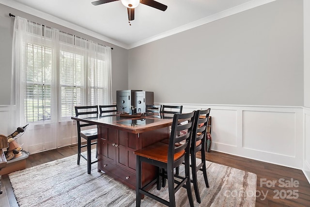 dining area with ornamental molding, ceiling fan, and dark wood-type flooring