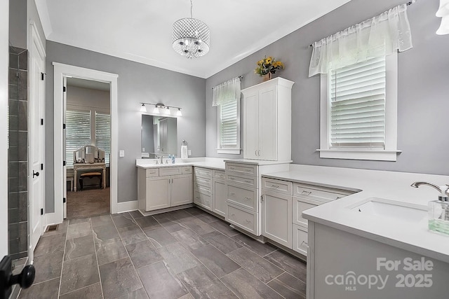 bathroom featuring vanity, a wealth of natural light, and a notable chandelier