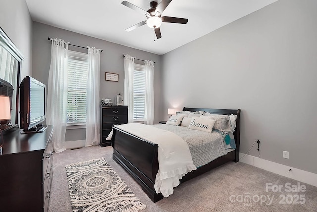 carpeted bedroom with ceiling fan and multiple windows