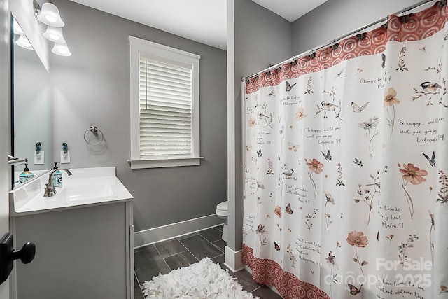 bathroom featuring vanity, toilet, and curtained shower